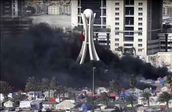الدخان الأسود يلف دوار اللؤلؤة وسط المنامة جراء احتراق خيم المتظاهرين بعد هجوم الشرطة الدموي عليهم أمس