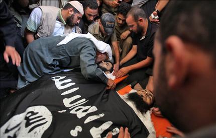 والد شهيد ينتحب فوق جثمانه في مخيم رفح في غزة أمس بعد يوم من مقتله مع آخر في غارة للاحتلال (ا ب ا) 