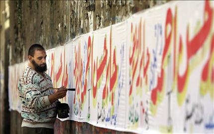 خطاط مصري يعمل على لافتات لمرشح للانتخابات البرلمانية في القاهرة أمس (أ ب) 