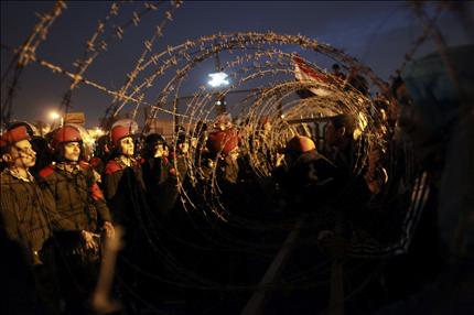 المتظاهرون أمام حاجز للجيش قرب مقر وزارة الدفاع في القاهرة أمس (رويترز) 