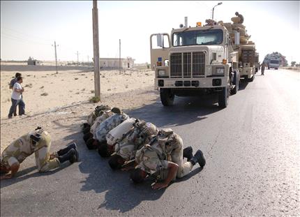 جنود مصريون يقيمون الصلاة بعد وصولهم إلى بلدة العريش في شمال سيناء أمس (أ ف ب) 