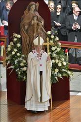 البابا فرنسيس يقف أمام تمثال للعذراء مريم والمسيح خلال قداس التنصيب في الفاتيكان أمس (أ ف ب) 