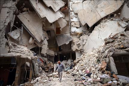 رجل يسير وسط مبان مدمرة في حلب امس (ا ف ب) 