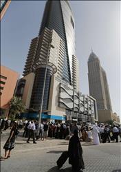 موظفون يخلون مكاتبهم في مدينة دبي الإماراتية بعد ذعرهم من ترددات الزلزال في إيران أمس (أ ف ب) 