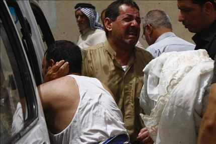 عراقي ينتحب على أحد أقاربه خلال تشييعه في النجف أمس (رويترز) 