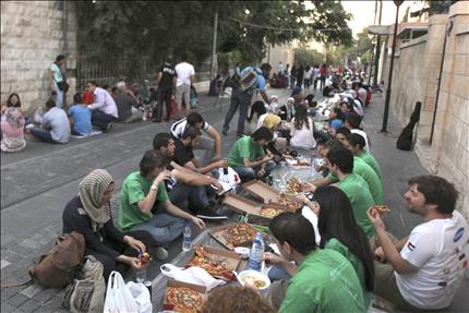 أردنيون يتناولون الإفطار تلبية لدعوة اطلقت على موقع «فايسبوك» في عمّان أمس الأول. (رويترز) 