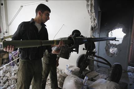 مسلح يستعد لاطلاق قذيفة من داخل منزل في حي جوبر في ريف دمشق امس الاول (رويترز) 