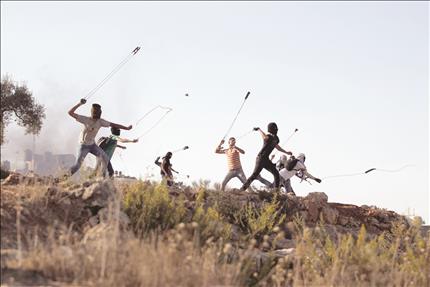 فلسطينيون يرشقون قوات الاحتلال بالحجارة خلال اشتباكات قرب رام الله في الضفة الغربية أمس (رويترز) 