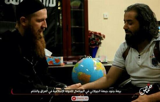 ابو يوسف المصري (الى اليمين) يصافح عمر الشيشاني خلال تسليم "النصرة" مدينة البوكمال الى "داعش" امس