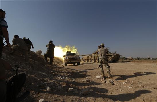 مسلحون يطلقون النار خلال اشتباكات مع القوات السورية قرب معسكر وادي الضيف في ريف إدلب أمس الأول (رويترز)
