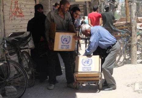 من توزيع مساعدات انسانية في مخيّم اليرموك أمس (أ ف ب)