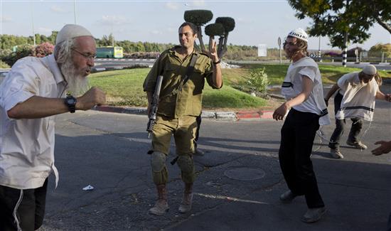 جندي إسرائيلي يرقص مع مستوطنين متشددين قرب "الحدود" مع غزة أمس (ا ب ا)