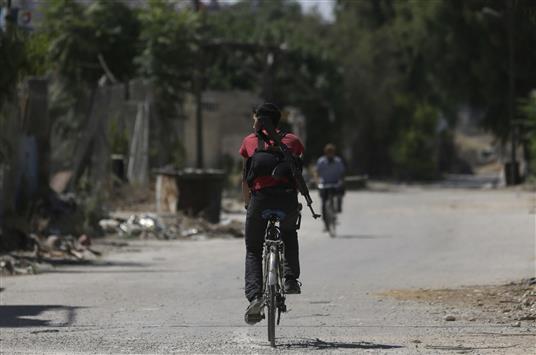 مسلح على دراجة هوائية في جوبر في ريف دمشق امس (رويترز)