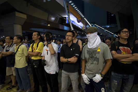 محتجون يغلقون مدخلا لأحد مقارّ الحكومة في هونغ كونغ امس (رويترز)