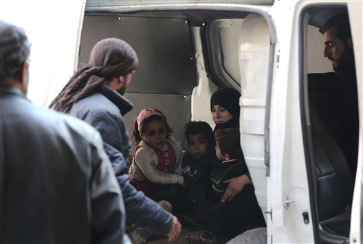 سوريون ينقلون عائلة من قرية كفربطنا في غوطة دمشق بعد تعرض المنطقة الى القصف امس (ا ف ب)