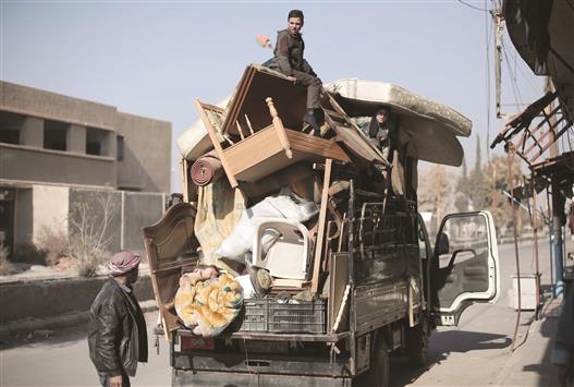 سوريون ينقلون أغراضهم من بلدة النشابية في غوطة دمشق امس (ا ف ب)