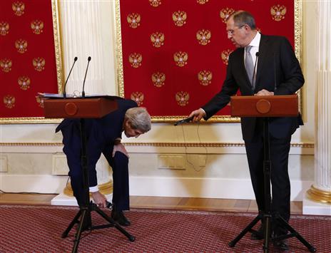 لافروف يحاول مساعدة كيري بعد ايقاعه سماعة الترجمة خلال مؤتمر صحافي مشترك في موسكو أمس (ا ب ا)