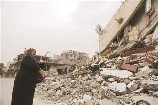 إمرأة تنتحب خلال رؤيتها لمنزلها المدمر في تدمر أمس الأول (رويترز)