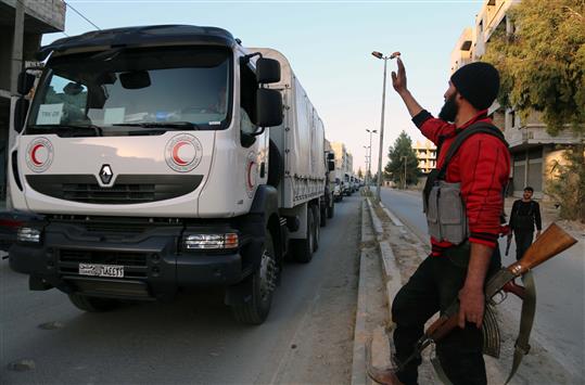 مسلح قرب شاحنة مساعدات للهلال الأحمر السوري في عين ترما في غوطة دمشق أمس الأول (ا ف ب)