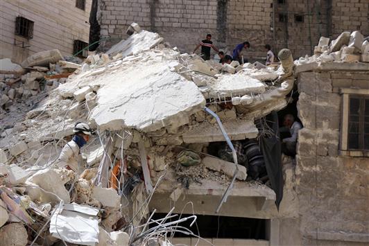 شبان يفتشون عن ناجين داخل مبنى مدمّر في حي الصاخور في حلب أمس (ا ف ب)