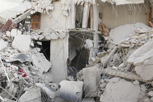 سوري يبحث عن أحياء تحت أنقاض منزل مدمّر في حي القاطرجي شمال حلب. (ا ف ب)