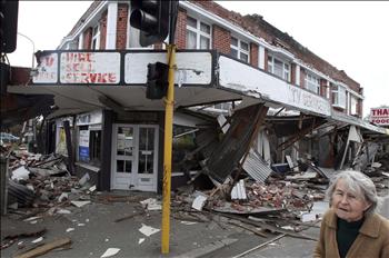 نيوزيلندية تمر أمام مبنى مدمر من الزلزال في كرايستشيرش أمس